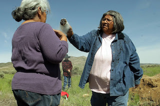 Two native women standing in a field