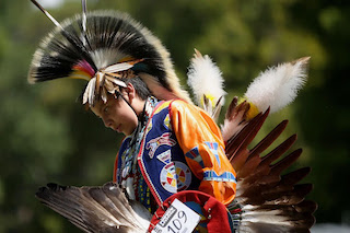 Young Native boy dressed in traditional native clothing while competing in dance competition