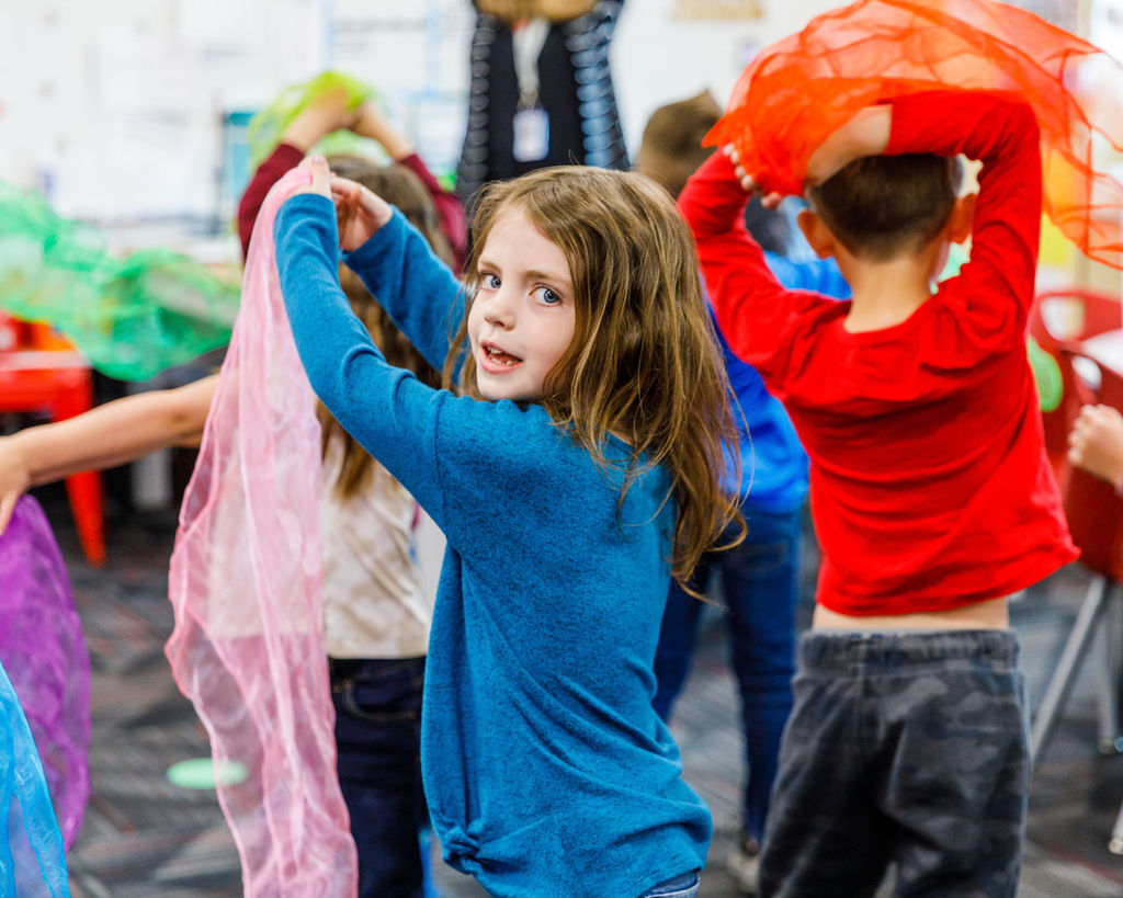 Dancing like bees to pollinate the flowers, second-grade students dance the plant life cycle.